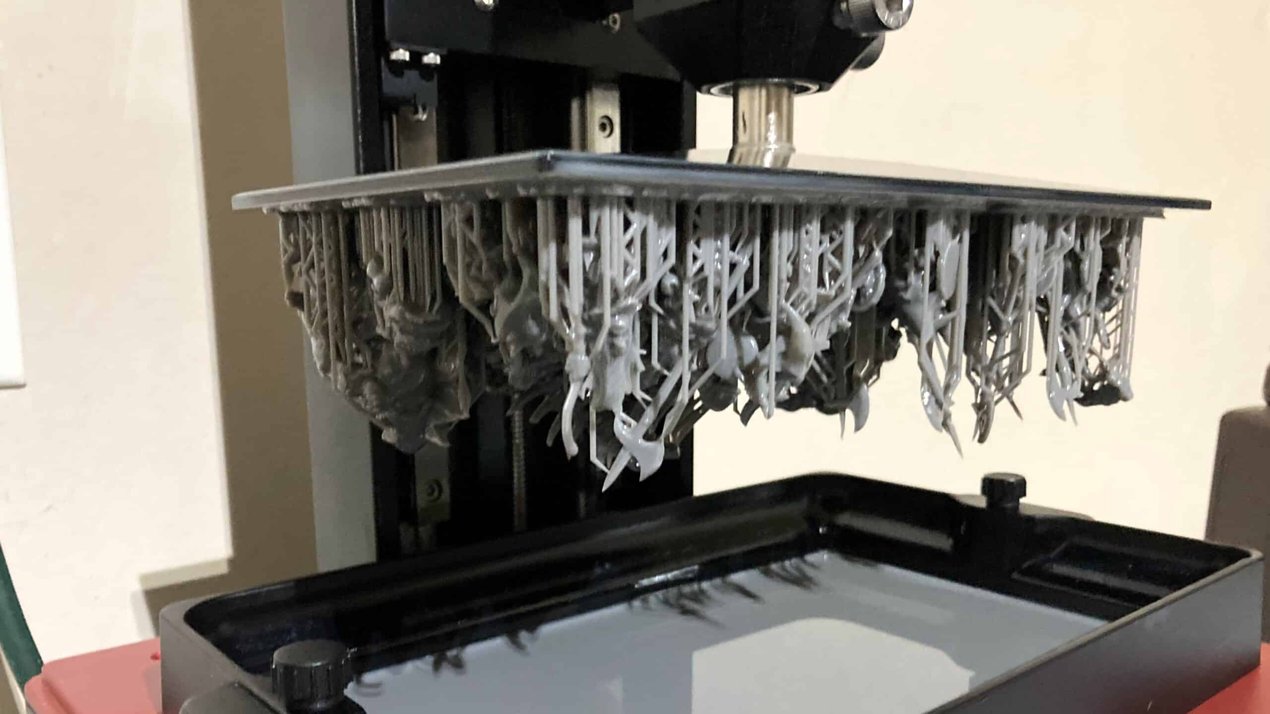 An Elegoo Mars 4 3D printer with a build plate full of miniatures